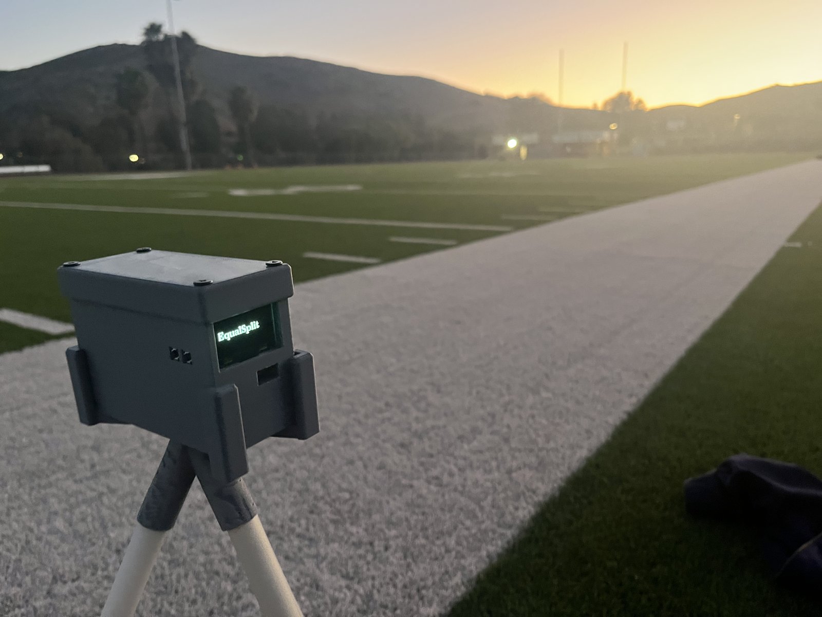 EqualSplit timing gate on its tripod beside the field